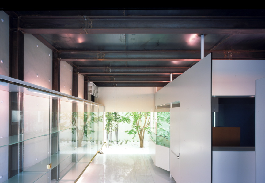 Mo House この住宅は、商店街と住居地が混在する比較的密集した18坪足らずの狭小地に建つ、コンパクトなスチールシートの都市型住宅である。1階には、住宅に付属する店舗と視覚的に連続する中庭があり、上階にそのクライアントの住まいがある。神戸の地形から、海と山を結ぶ南北軸に両方向をペアガラスのサッシュで全面開放させ、敷地奥に中庭を確保したことでパッシブにとらえた自然採光と風抜きが十分に機能できている。そして、2階に個室、3階にリビングをそれぞれ配し、下階から上階に上がるにつけ内部ヴォリュームが増し、さらに開放感と光量が増大するように考えている。サニタリーのある屋上テラスは、デッキと緑のある空中庭園としてアウトリビングとなり、都市にいながらにして天空と山と海側の風景が楽しめる場所である。<br />スチールがもつ魅力は、モダニズムの時代に確立された構造的規制を超える可能性がある材料であると思えるからで、まだその応用と展開が可能と私自身は確信している。そして構造材としてのスチールシート材のもつ性能もさることながら、建築のクオリティの選択としてスチールシートを外装材として考えている。<br />9mmのスチールシートの使用は、スチール自体の素材感の強さや強度よりも、厚さが語りかける質感を期待するからである。その質感は、ミースが使う石材の厚さと同様に、安心感と建築のクオリティを保証してると確信するからである。車は車であり軽くて強度が必要で、車体を包む薄肉のスチールシートで、決して建築のように質感は問われないはずである。建築のスチールシート化は、単なるプロダクト的な工場制作の工法における扱いだけでもなかろう。素材の厚さは、やはり空間の大きさに比例し、質感に反映すると思える。質感が求められるのは、使われるもの以上に人が住まうものであるという決定的な点にある。