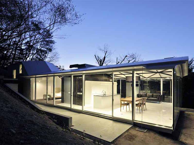 Steel Truss この住宅は、山間の自然木を残した傾斜地に建つ。場所性のもつポテンシャルから、樹木をイメージするオーガニックな意匠性と構造体が連続するような空間を考えた。そして、この大きなスチールトラスの大屋根を、サニタリースペースと茶室に見立てたゲスト室の2つのモノコック構造のスチールボックスが支えている。<br />四畳半のこの鉄の茶室は、厚さ6mmのスチールプレートで一体成型され、運搬、板材の規格寸法、溶接等を複合的に考慮して、ヴォリュームを決定している。ほこらのようなプライベート性の高いこの茶室のトップライトを開放すると、ダイレクトに自然の気配が侵入する中庭空間へと反転し、閉鎖性は一気に開放される。 開口部を構成する要素を視線からなくし、ピクチャーフレームで切り取ったエッジのディテールによって、自然の揺らぎの変化がより敏感に五感に作用し、意識を無限に開放する空間を期待した。<br /><br />設計するにあたり、鋼構造を選択した理由をひとことで言えば、材料の確かさである。高強度や高耐久性はもちろん、鉄の加工技術の発展で変化自在であり、加工精度の正確さ、そして、建築パーツのプロダクト的な工場制作が可能である。またさらに、現場施工の簡略化、素材自身のクオリティやコスト面など総合的に捉えれば、私自身、最も信頼のおける、優れものの建築材料であると考えている。<br />今後、鉄を用いてつくってみたい空間は、従来の柱、梁の規制に捉われない、構造から解き放たれた建築。たとえば、モノッコック的な建築の試みの、船や車、乗り物のような面で包まれた大空間であり、その無限の可能性に魅力を感じている。一方で、無機質なクールな素材であるが、自然や五感に連動した空間を目指したい。